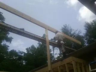 Carpenter setting a ridge beam over a new addition frame — Ice Dam Removal by Roofing Brothers in Dubois