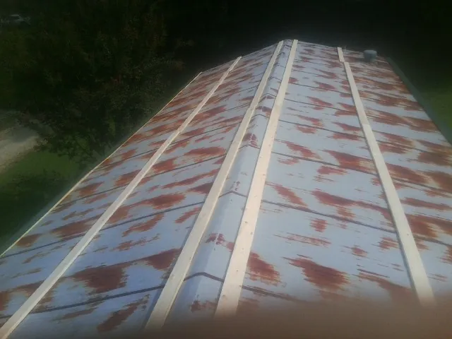 Rusted metal roof panels with new wood purlins before replacement — Storm Damage Roof Repair in Dubois by Roofing Brothers