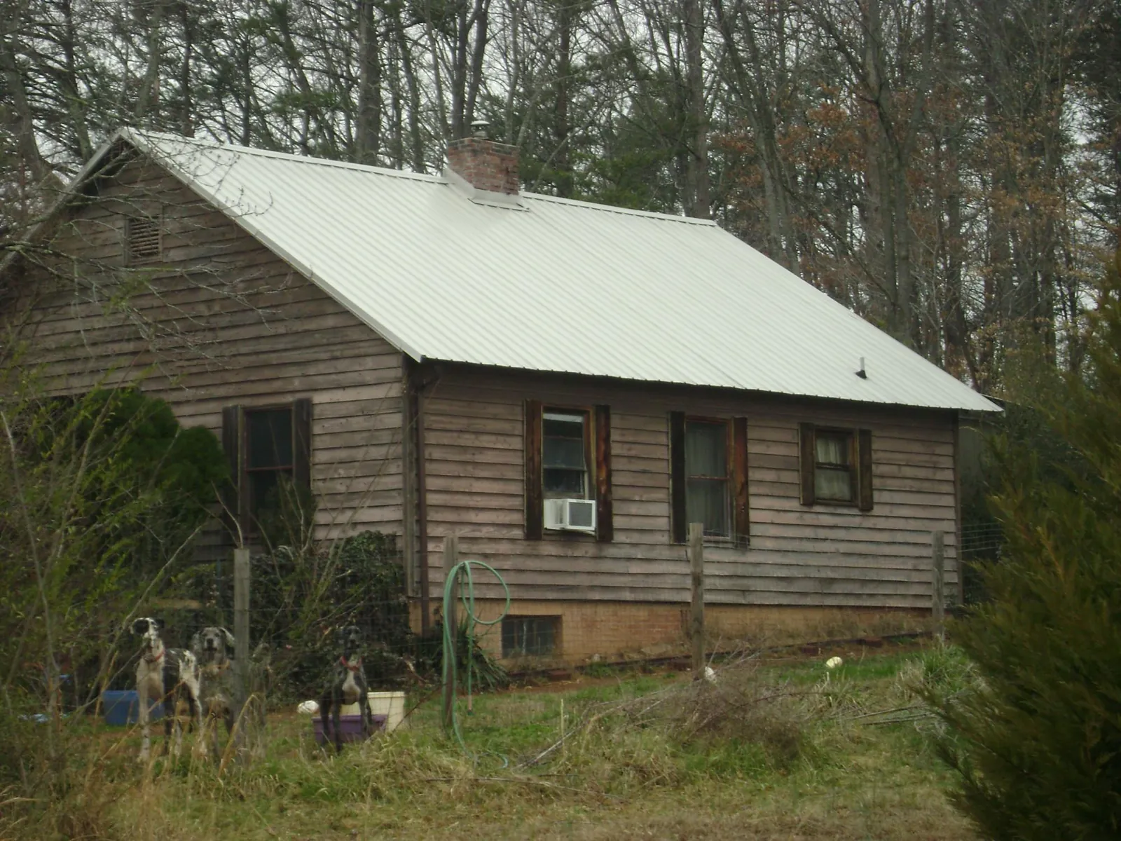 White metal roof on an old wood sided farmhouse, from a Metal Roof Installation job in Dubois